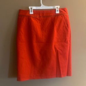 NWOT Calvin Klein coral/red skirt. Gold accents. Size 10.